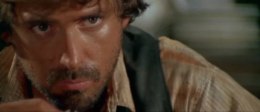 Django Kill (1967) movie still: closeup — A man is positioned in an interior space with simple textures in the background. He is staring directly…