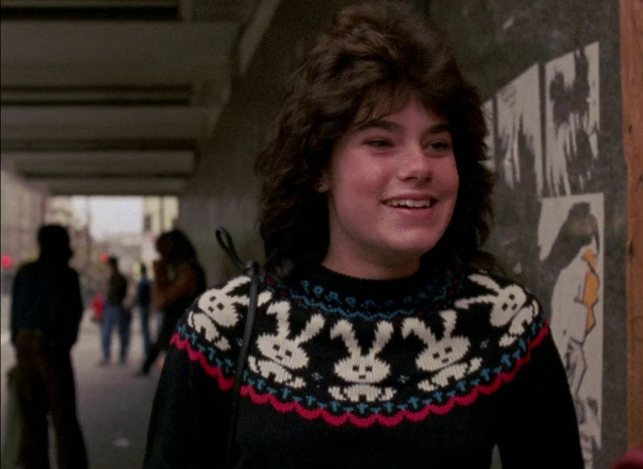 Streetwise (1984) movie still: medium — A teenage girl stands in a concrete pedestrian underpass featuring graffiti-covered walls. She is walking…