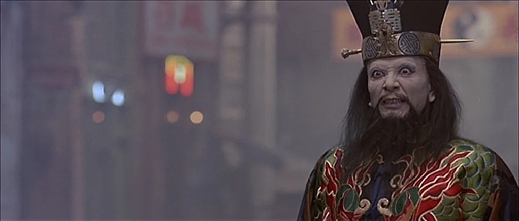 Big Trouble in Little China (1986) movie still: medium — A misty, dimly lit city street at night with glowing, out-of-focus neon signs. A sorcerer…
