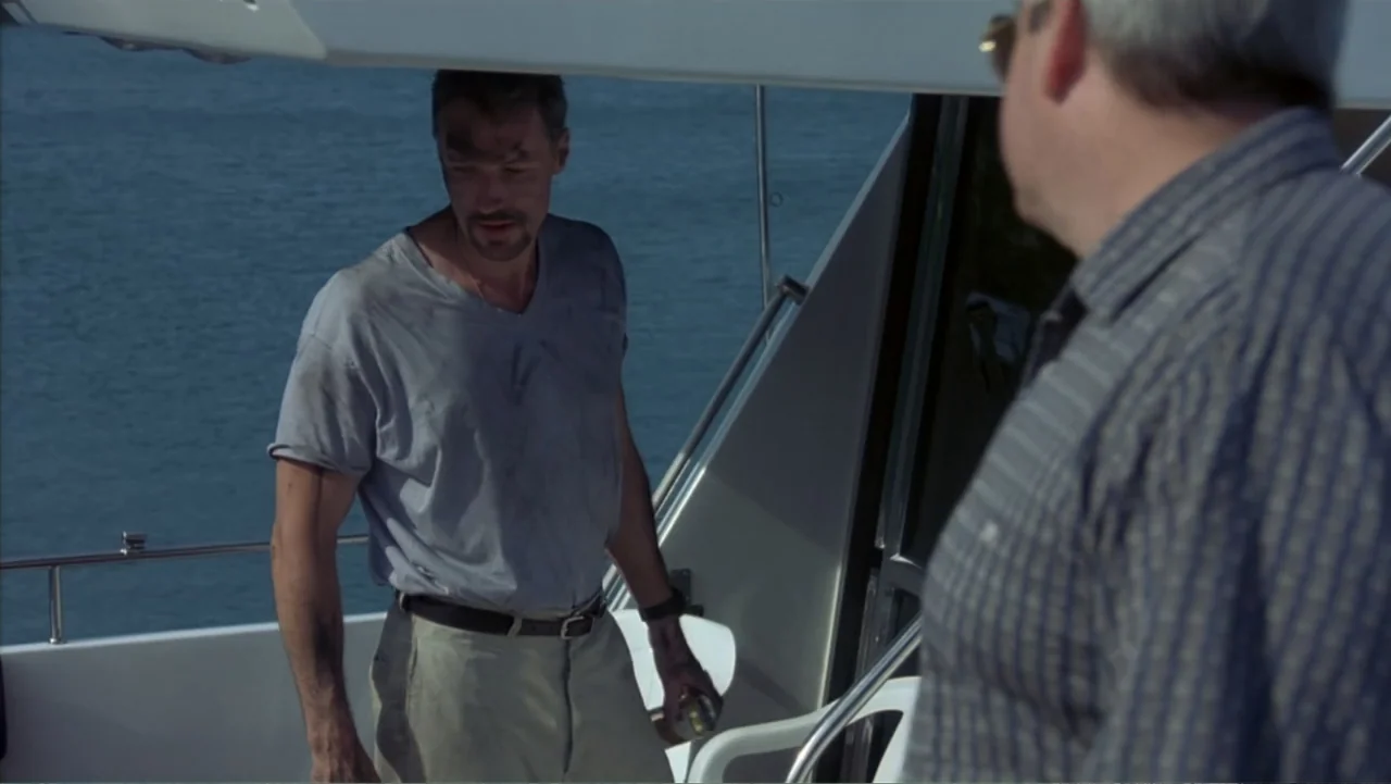 Behind Enemy Lines (2001) movie still: medium — A man stands on the deck of a yacht with the open sea behind. He looks toward a second man whose…