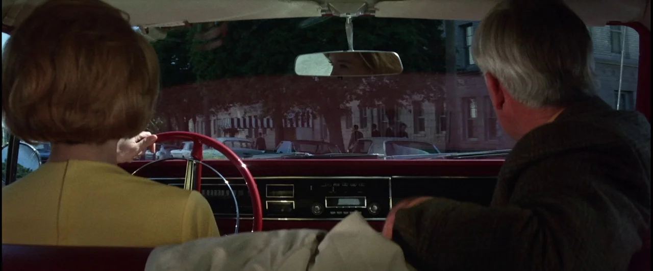 Point Blank (1967) movie still: medium — The interior of a mid-1960s vehicle shows a woman driving and a man passenger. Outside the windshield, a…