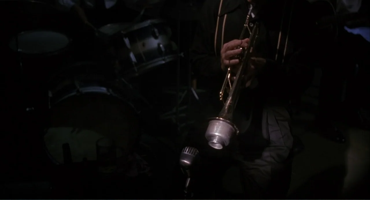 Wild Orchid II: Two Shades of Blue (1991) movie still: medium — A dark, cramped musical performance space featuring a percussion set and a…