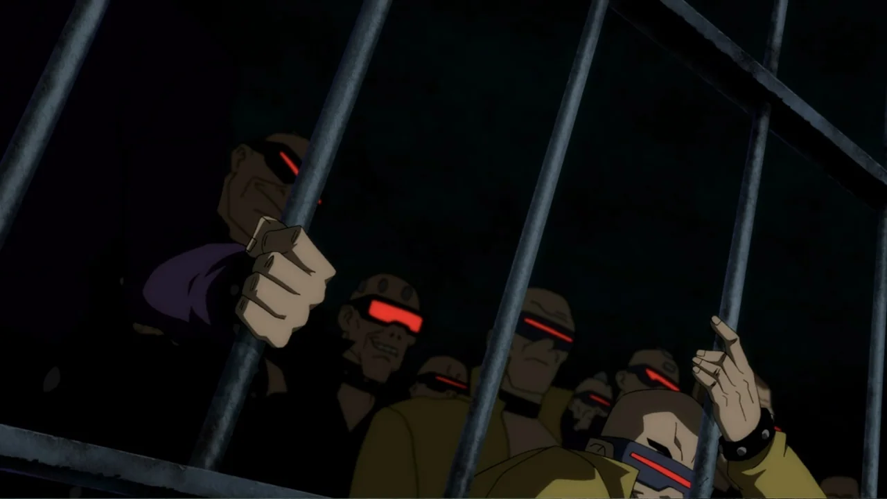 Batman: The Dark Knight Returns, Part 1 (2012) movie still: medium — A group of men stand in a dark, confined space behind heavy vertical bars. The…