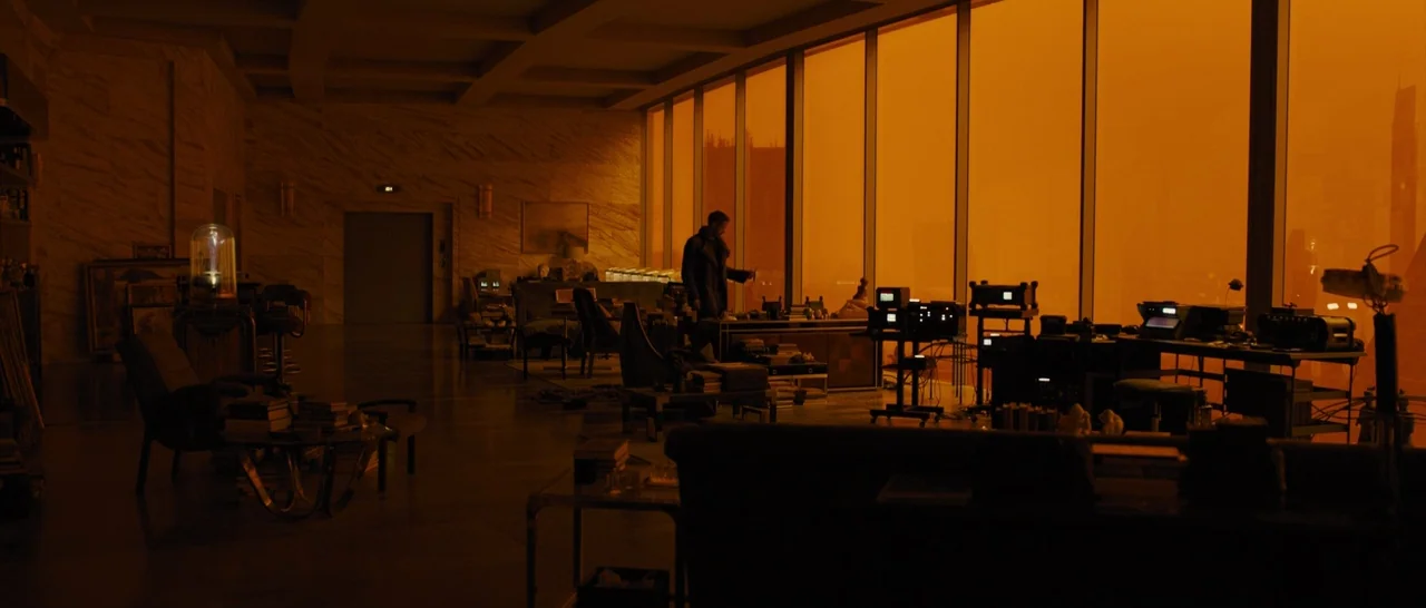 Blade Runner 2049 (2017) movie still: wide — A dark, modern luxury apartment interior features low-profile furniture and electronic equipment on…