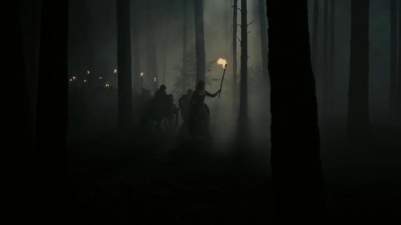Dark Shadows (2012) movie still: wide — A dark, dense forest is obscured by thick night fog and tall pine trees. A group of silhouettes walks…