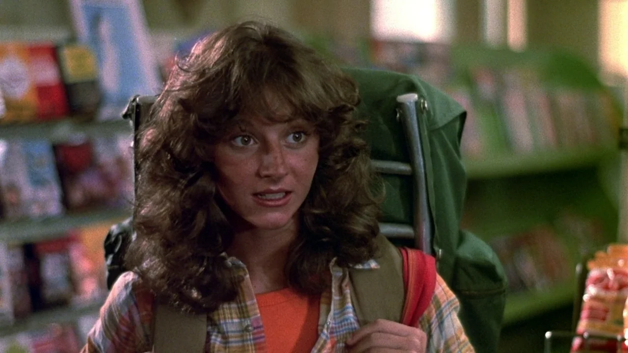 Friday the 13th (1980) movie still: medium — A well-lit convenience store interior features rows of merchandise on green shelving units. A young…
