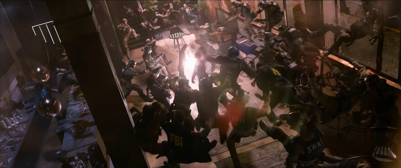 The Matrix Resurrections (2021) movie still: wide — A high-rise room with large windows is filled with debris and tactical equipment. A central…