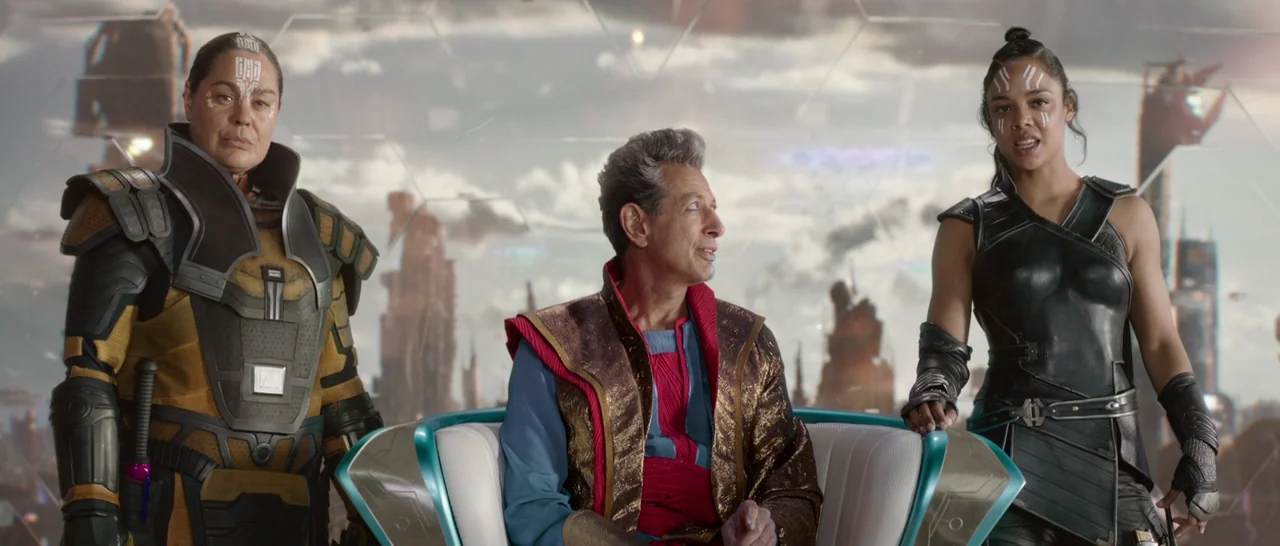 Thor: Ragnarok (2017) movie still: medium — An interior viewing chamber features a large glass wall overlooking a futuristic alien cityscape. Three…