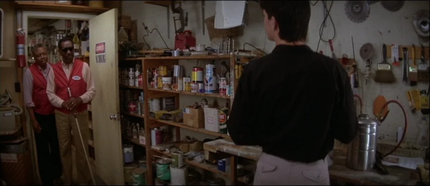 Blue Velvet (1986) movie still: medium — A cluttered utility room filled with shelves of paint cans and various maintenance tools. Two store…