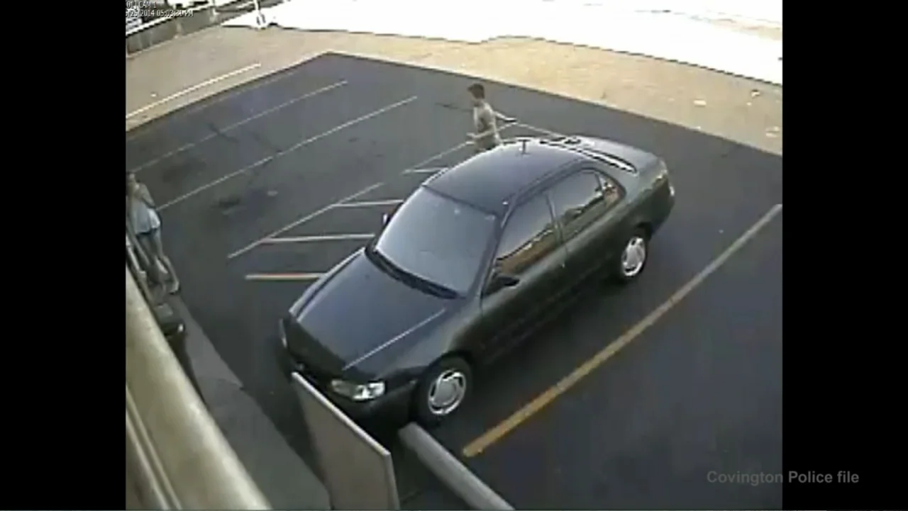 Requiem for the Dead: American Spring 2014 (2015) movie still: wide — A high-angle surveillance view of an asphalt parking lot under daylight…