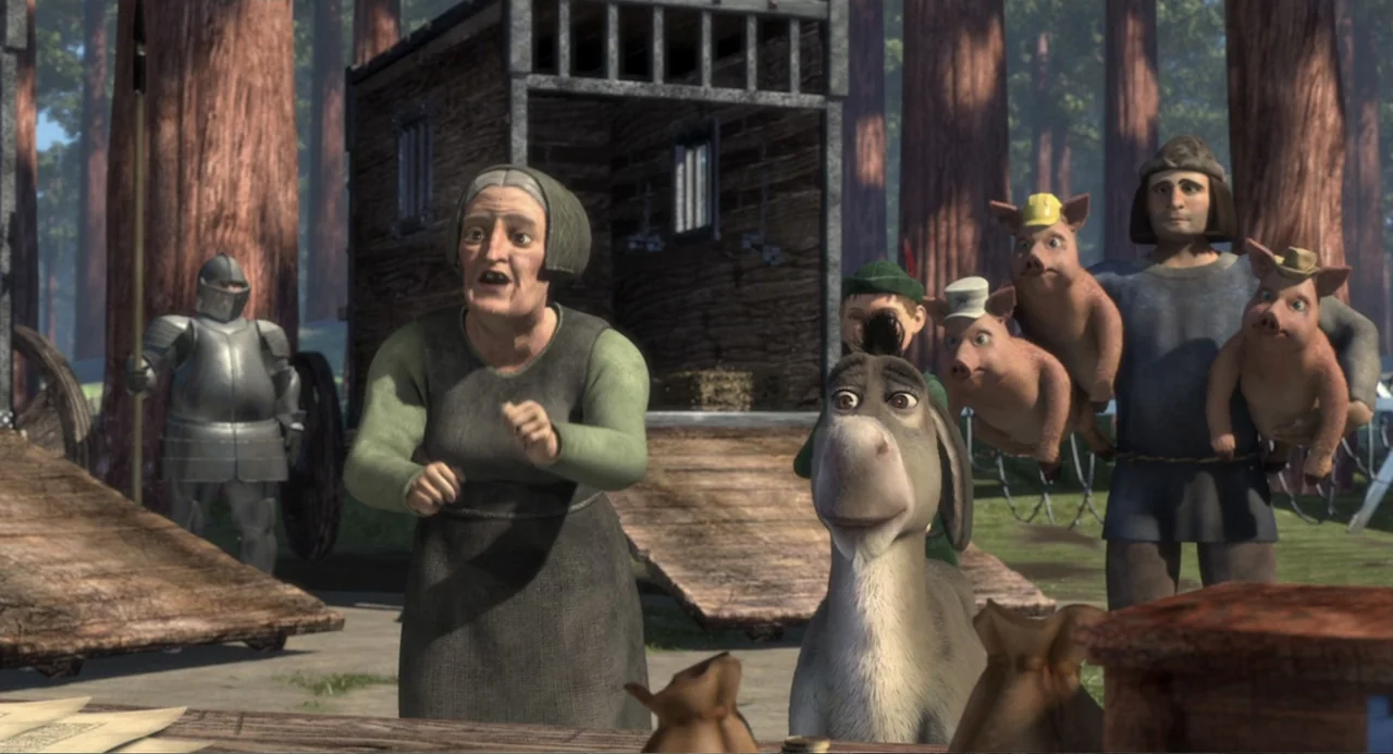 Shrek (2001) movie still: fullbody — A clearing in a dense forest features a wooden hut and several fantasy figures. An elderly woman stands beside…