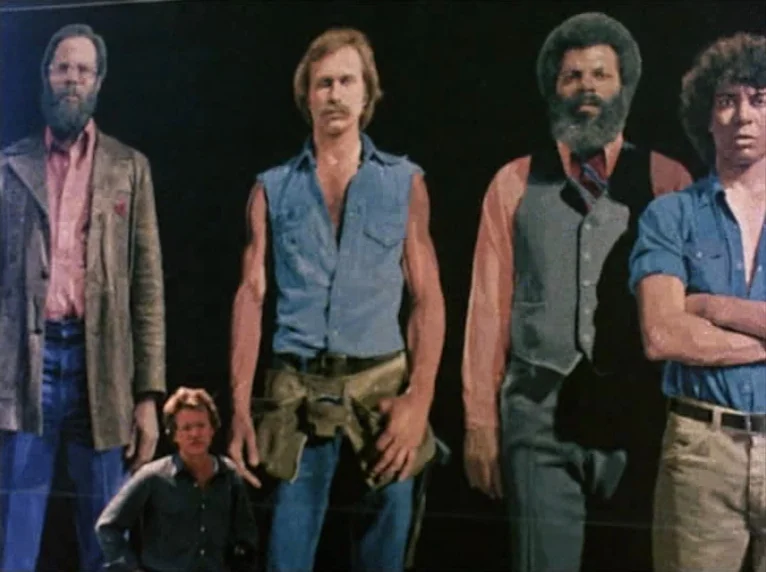 Mur Murs (1981) movie still: fullbody — Five men stand in a line against a solid black backdrop in a studio. The figures appear as a group portrait…