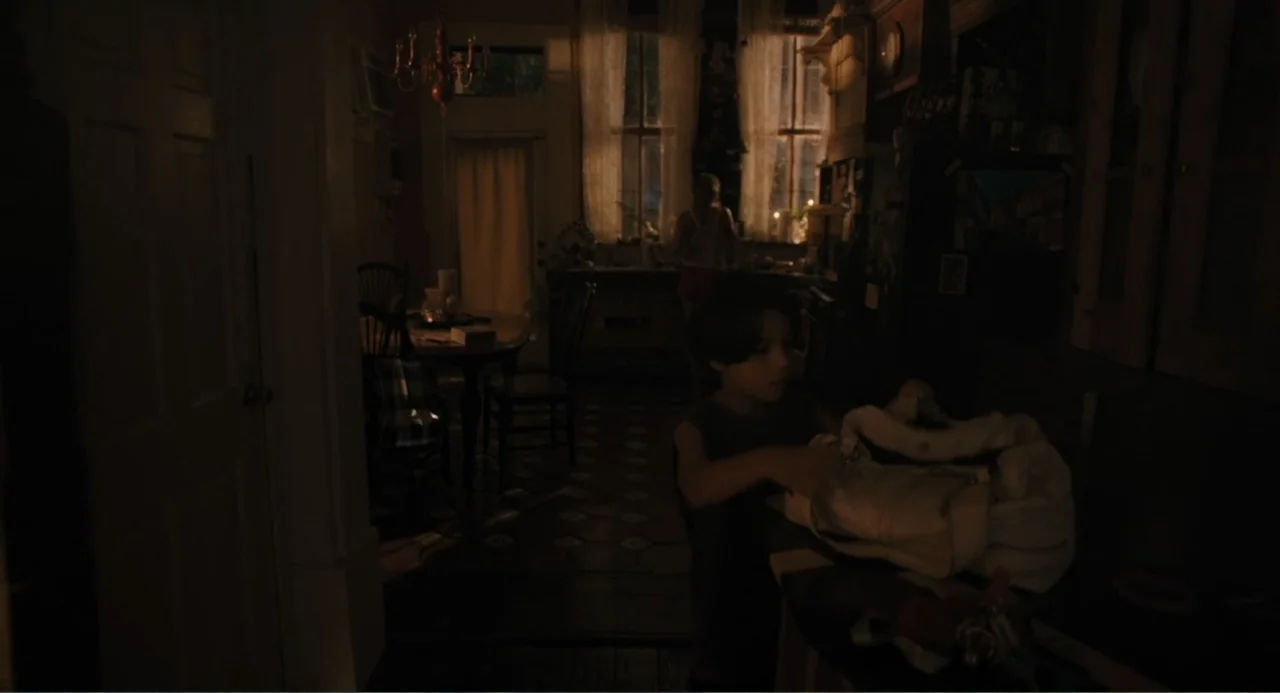 Mona Lisa and the Blood Moon (2022) movie still: medium — A dimly lit room features a tiled floor, dark wooden furniture, and lace window curtains.…