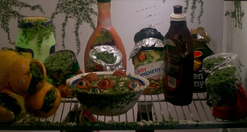 A Nightmare On Elm Street 5: The Dream Child (1989) movie still: closeup — A refrigerator shelf holds various containers of food covered in thick,…