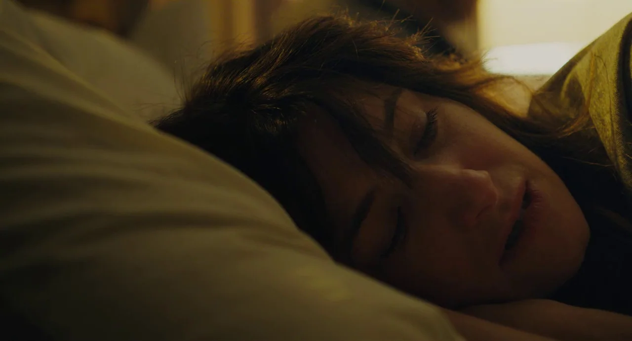 Private Life (2018) movie still: closeup — A close-up of a person resting their head on a white pillow. The subject lies sideways with closed eyes…