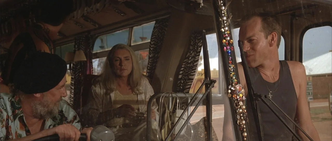 The Adventures of Priscilla, Queen of the Desert (1994) movie still: medium — The interior of a tour bus features patterned curtains and hanging…