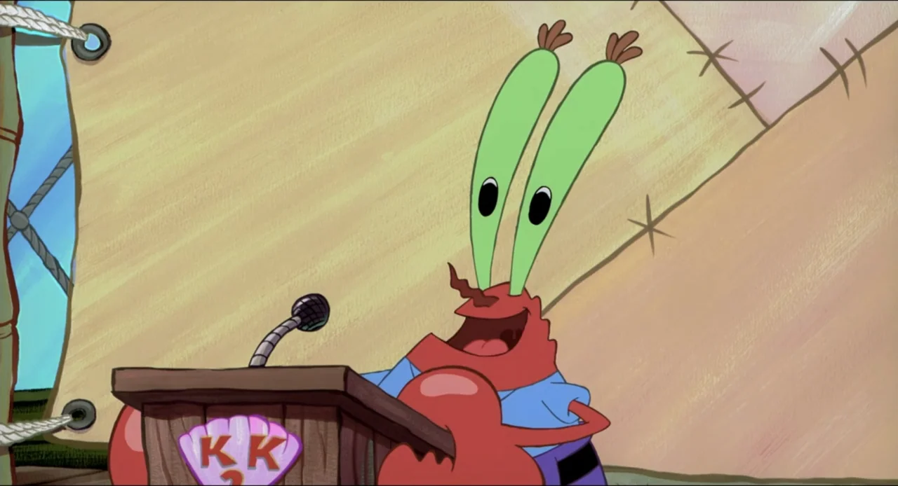 The SpongeBob SquarePants Movie (2004) movie still: medium — A light brown wooden podium stands in front of a neutral-colored background. Mr. Krabs…