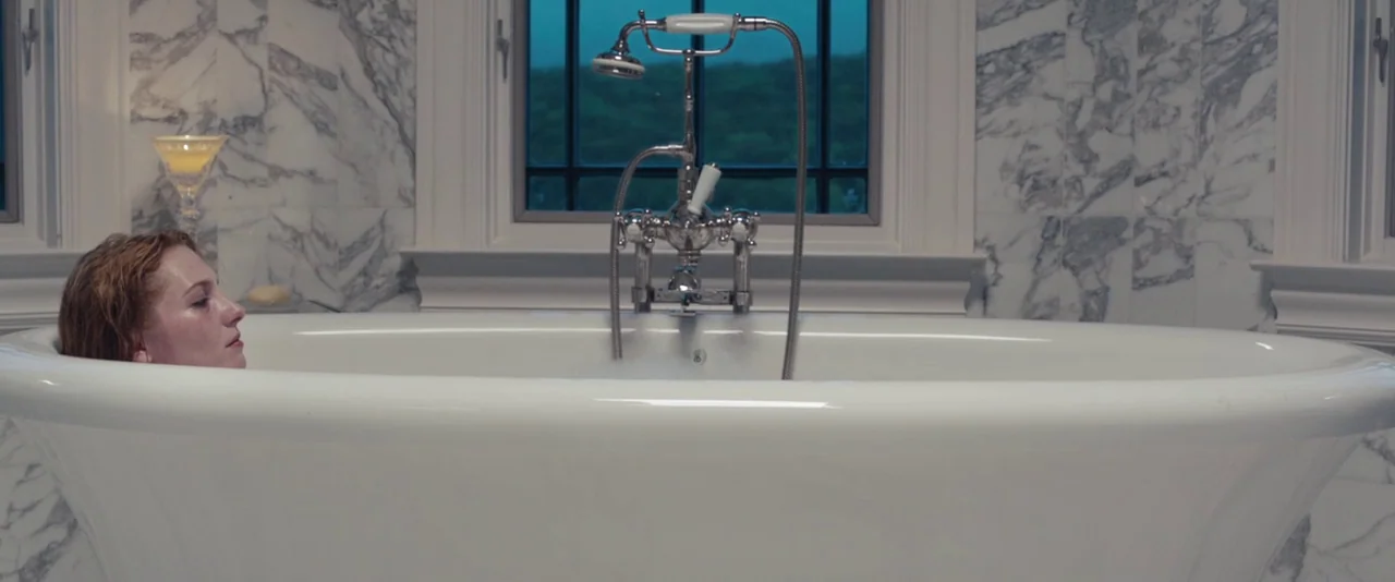 Kiss of the Damned (2012) movie still: medium — A luxury bathroom features floor-to-ceiling white marble walls and a central freestanding clawfoot…