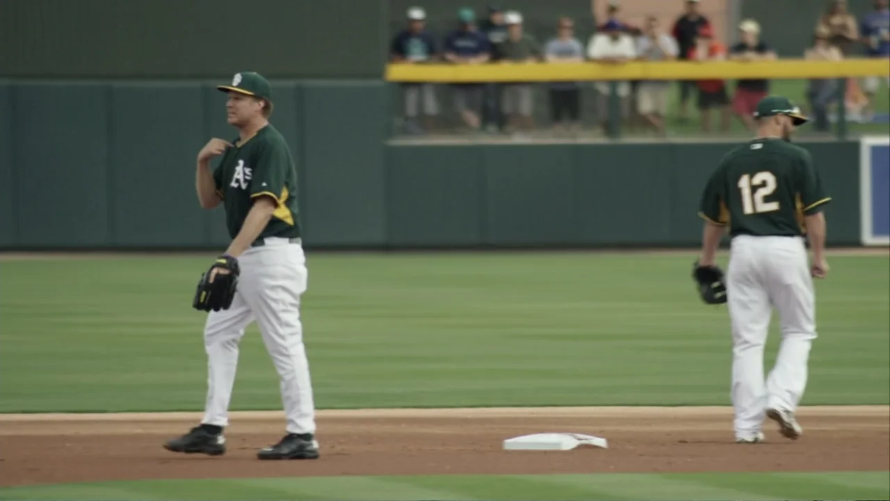 Ferrell Takes the Field (2015) movie still: fullbody — A professional baseball diamond with green turf and a dirt base path area. Two male baseball…