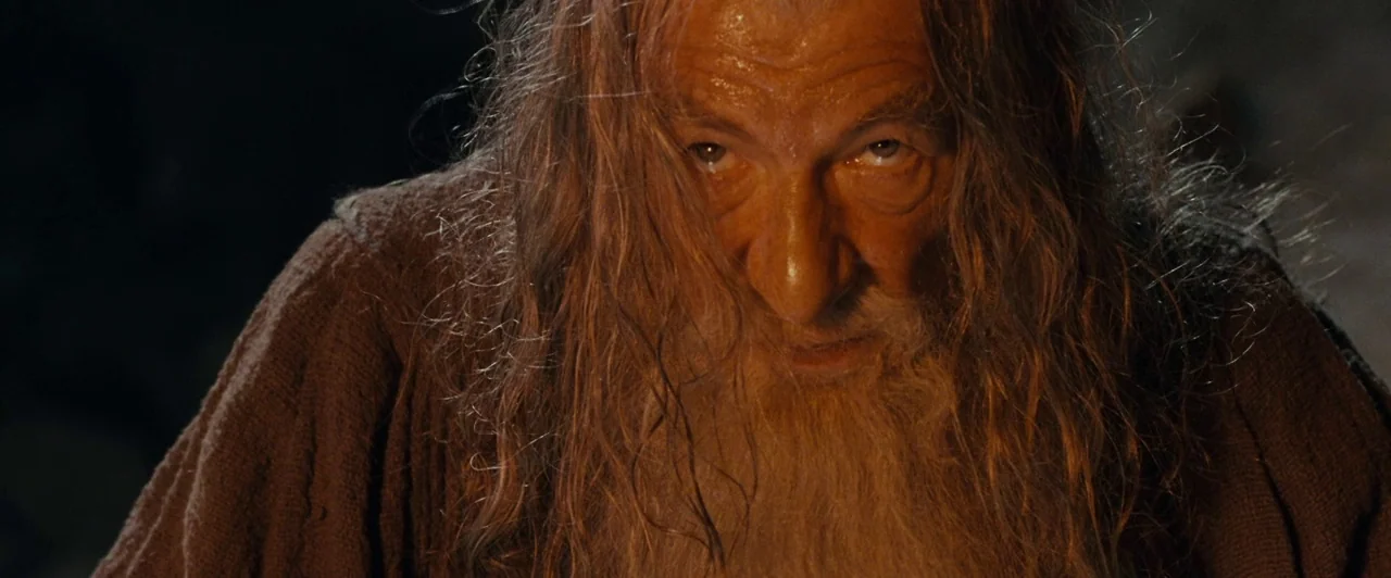 The Lord of the Rings: The Fellowship of the Ring (2001) movie still: closeup — A dark, dimly lit environment with textured stone walls in a…