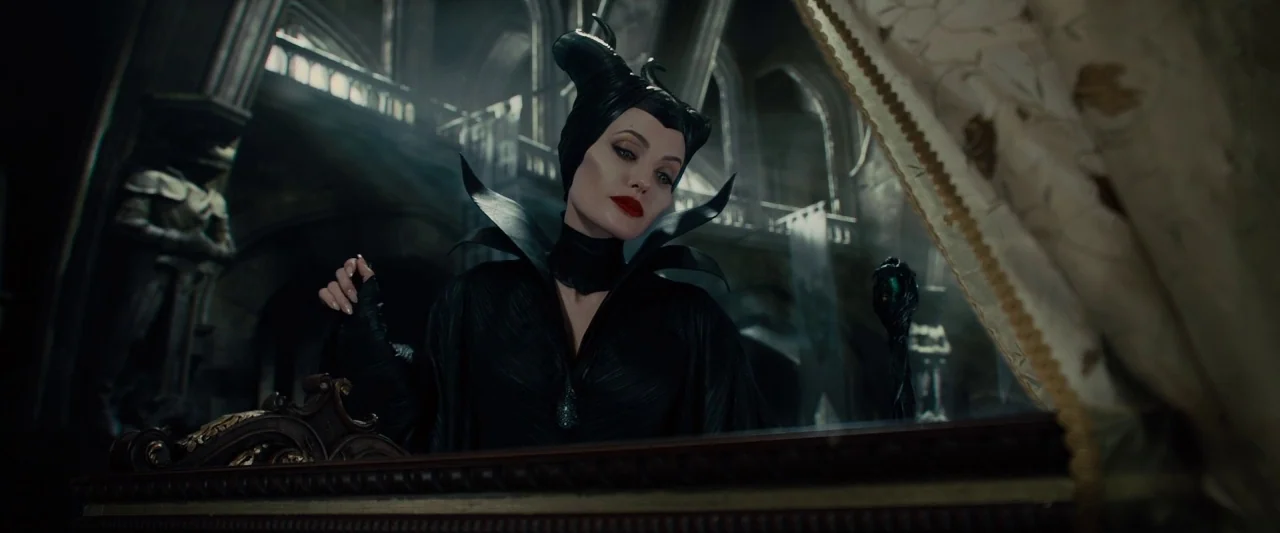 Maleficent (2014) movie still: medium — An expansive, dimly lit stone castle hall contains high vaulted ceilings and architectural details. A pale…