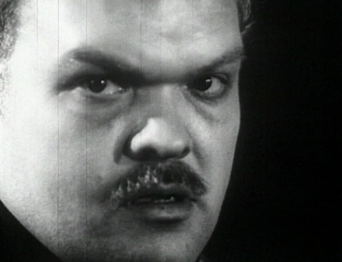 Dementia (Daughter of Horror) (1955) movie still: closeup — A close-up of a man's face against a dark, featureless background. The film displays…