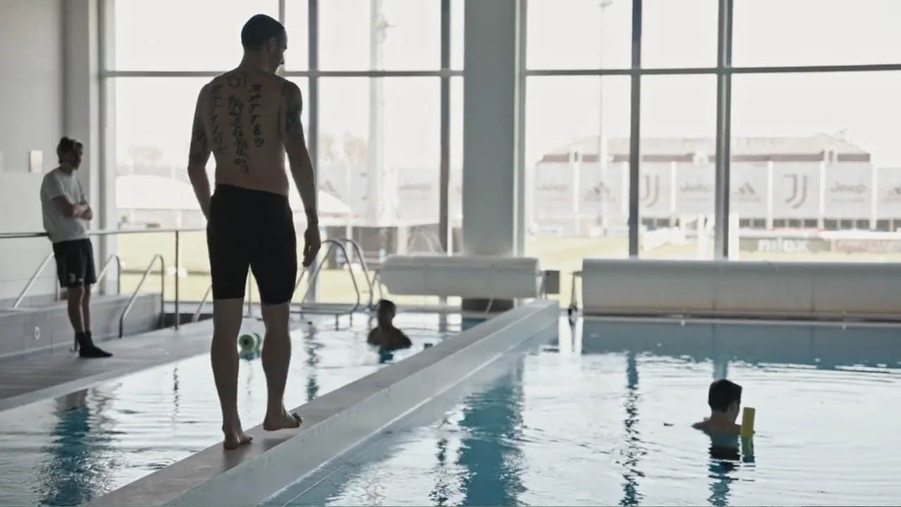 Federico Chiesa - Back on Track (2023) movie still: fullbody — An indoor swimming facility with floor-to-ceiling windows overlooking a sports…