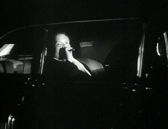 Dementia (Daughter of Horror) (1955) movie still: medium — A man sits inside the darkened interior of an automobile at night. He holds a cigar to…