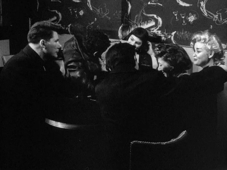 Shadows (1958) movie still: medium — A group of five young people sit together in a booth at night. The back wall features white chalk drawings on a…