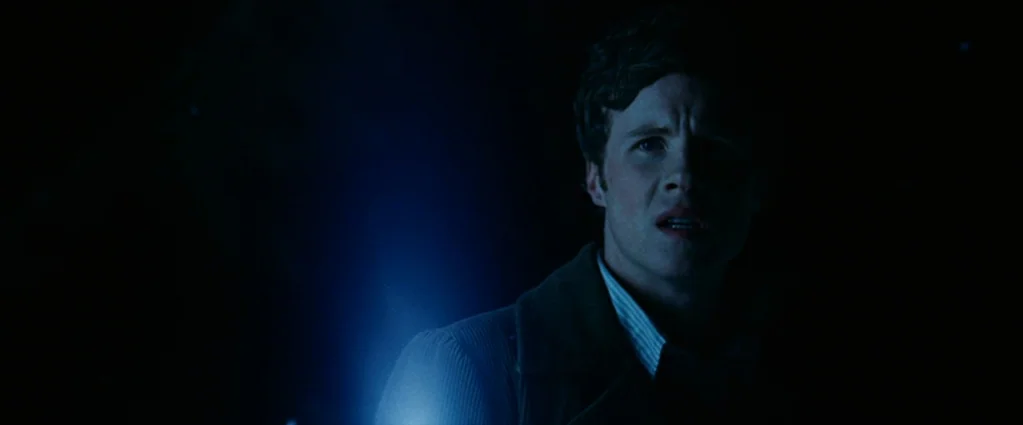 Wind Chill (2007) movie still: medium — A man stands in total darkness with only his face illuminated by a light. He looks away from the camera with…