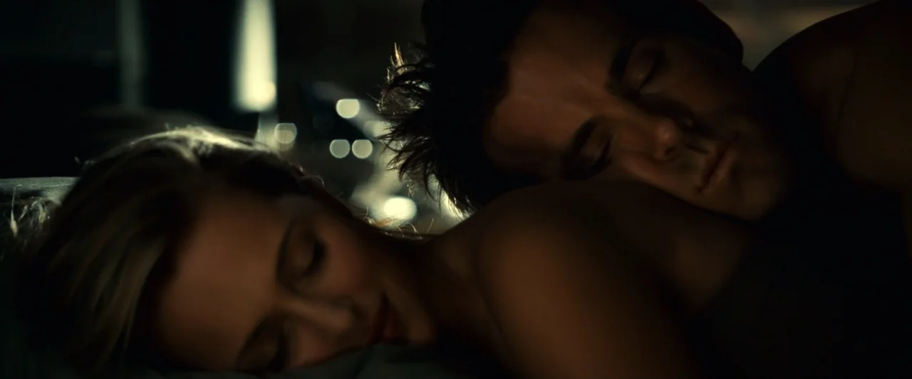 Green Lantern (2011) movie still: closeup — A dark bedroom at night contains two people resting closely together under blankets. They sleep with…