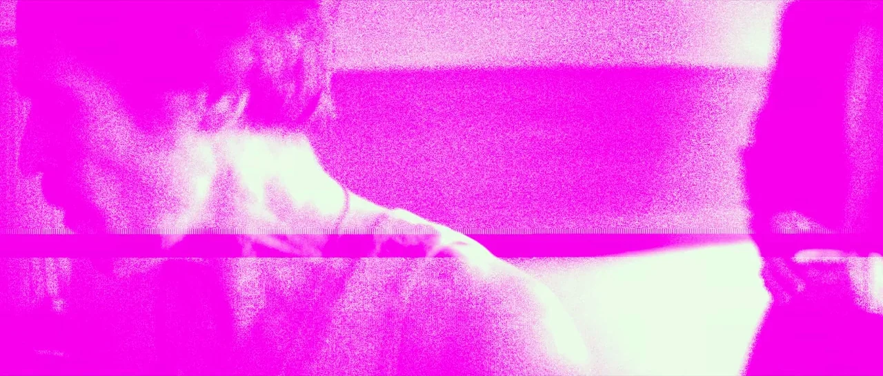 Dog Eat Dog (2016) movie still: closeup — A featureless, overexposed room bathed in intense magenta light with a horizontal digital glitch. Two…