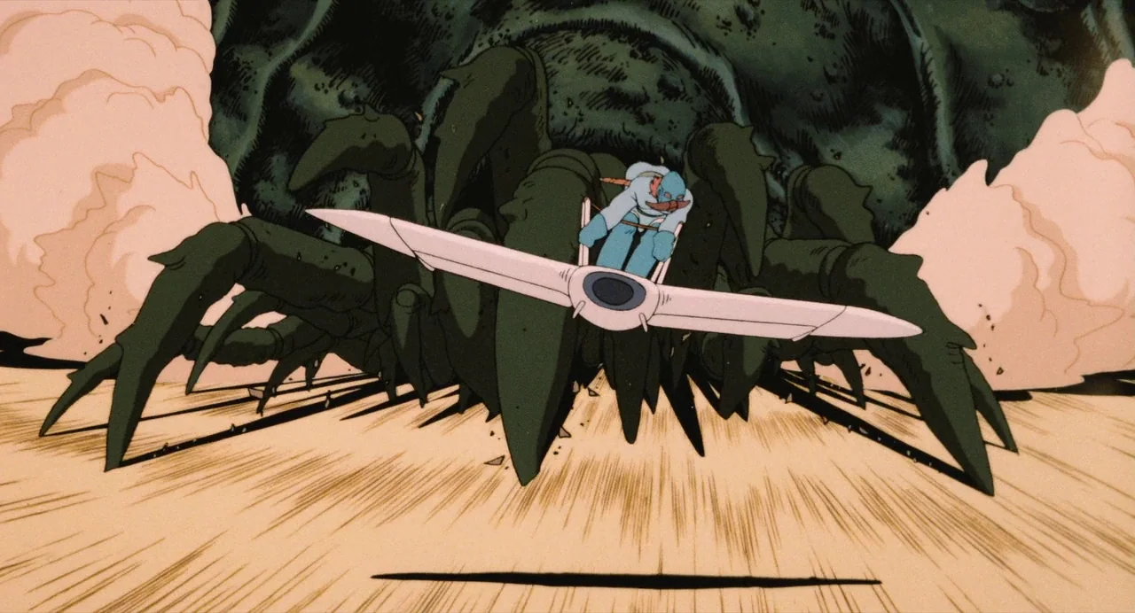 Nausicaä of the Valley of the Wind (1984) movie still: fullbody — A vast sandy wasteland features a giant dark green insectoid creature rising from…