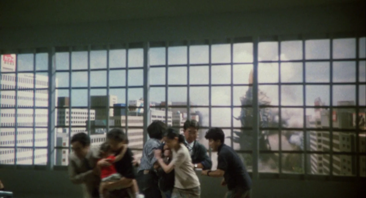 Godzilla and Mothra: The Battle for Earth (1992) movie still: wide — A spacious office interior features a large window wall looking out over a…