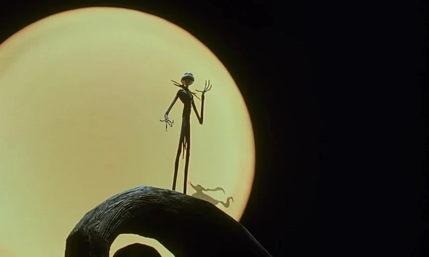 The Nightmare Before Christmas (1993) movie still: wide — A dark curved hillside rises against a vast, bright yellow full moon in darkness. A…