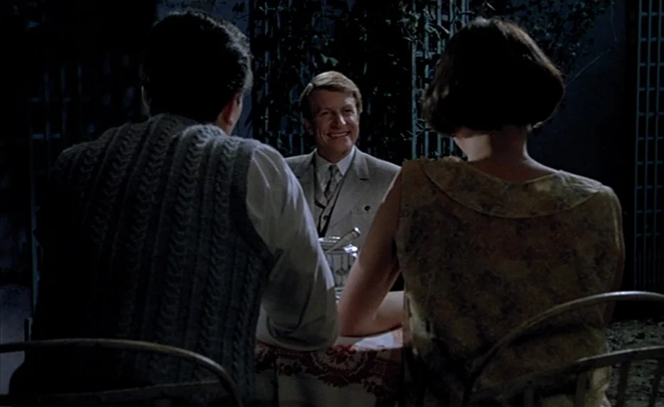 Mélo (1986) movie still: medium — An outdoor table is set with a patterned cloth and a white ceramic container. A man smiles while seated opposite…