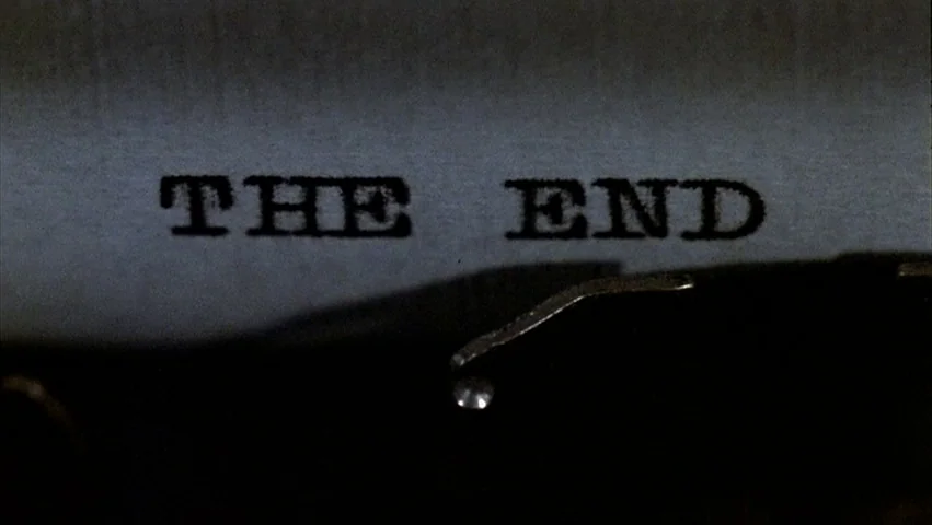 Hammett (1982) movie still: closeup — A close up view of a typed document resting in a typewriter carriage. The letters are pressed into the fibers…
