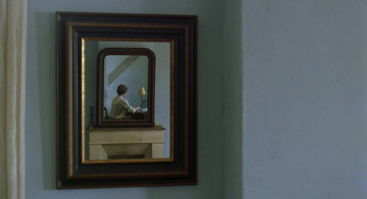 Swimming Pool (2003) movie still: medium — A pale blue wall features a large ornate framed mirror hanging prominently. The reflection reveals a…