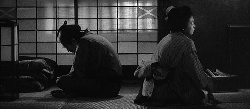 Red Beard (1965) movie still: medium — A traditional Japanese room features sliding paper screens and straw mat flooring. A man and a woman sit…
