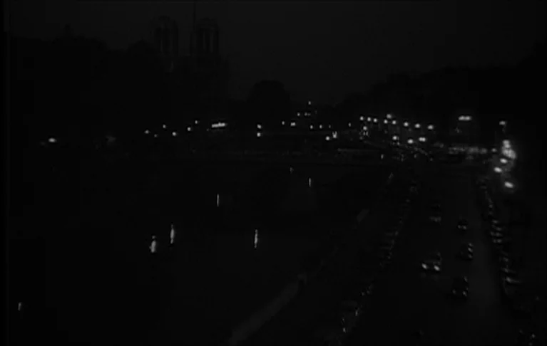 Le Signe du Lion (1962) movie still: establishing — A night view of a Parisian river with street traffic and distant building silhouettes. The scene…