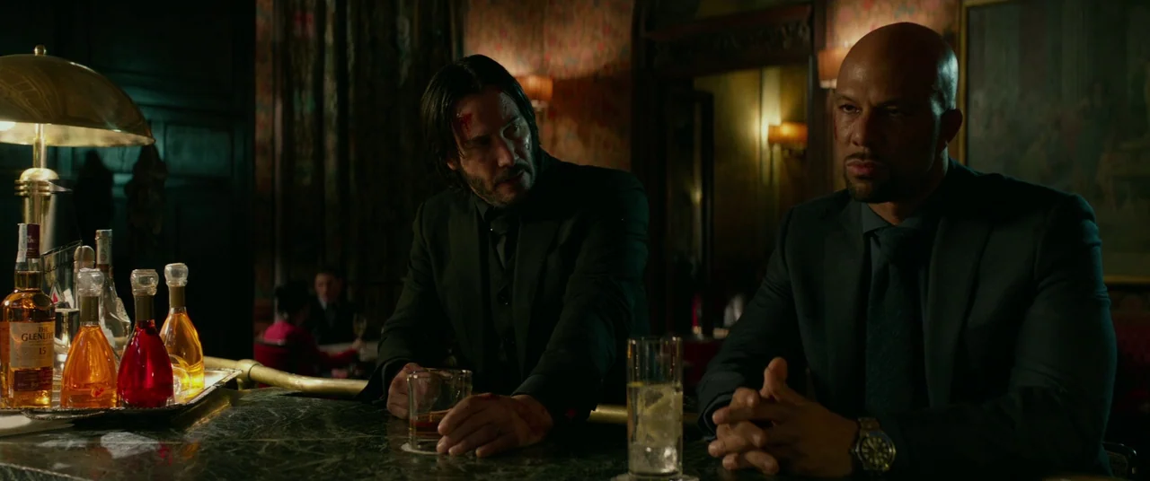John Wick: Chapter 2 (2017) movie still: medium — A dimly lit upscale establishment features a polished marble surface and ornate wallpaper…