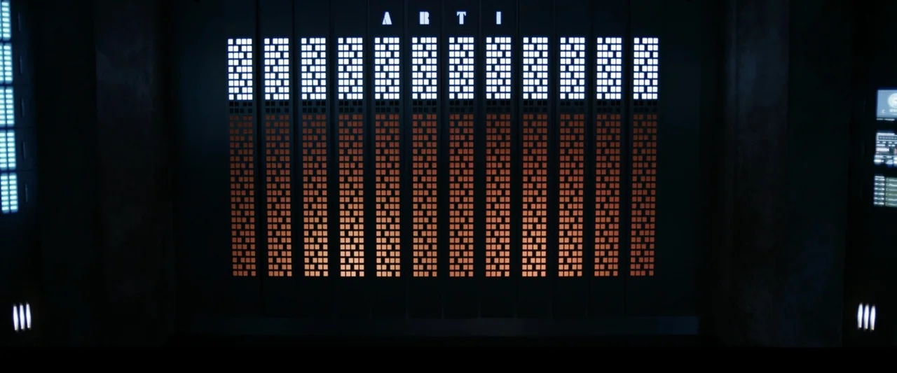 2036 Origin Unknown (2018) movie still: establishing — A dark futuristic interior wall features a large grid of glowing square status indicators.…