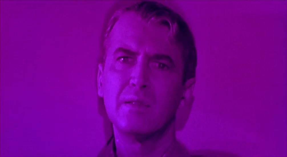 Vertigo (1958) movie still: closeup — A man stands before a solid, flat background. He is centered in the frame.