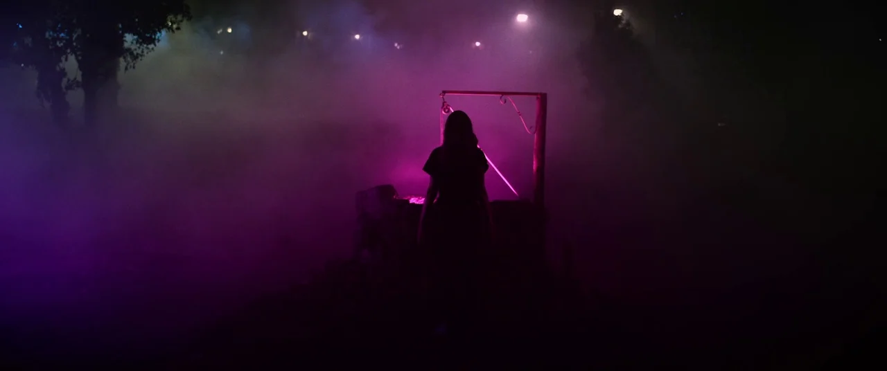 Colour Out of Space (2020) movie still: medium — A silhouette stands before an old wishing well in a thick, magenta-tinted foggy environment.…