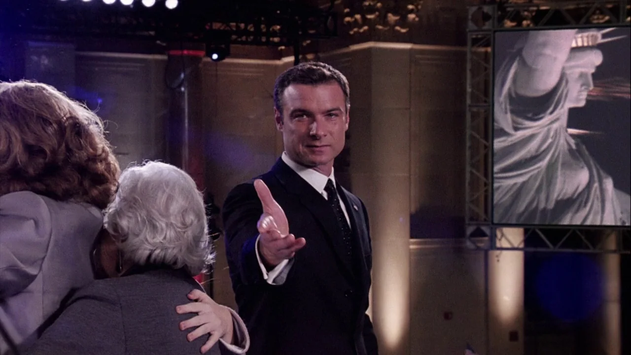The Manchurian Candidate (2004) movie still: medium — An interior event space features a man in a dark suit greeting someone off-screen. A large…