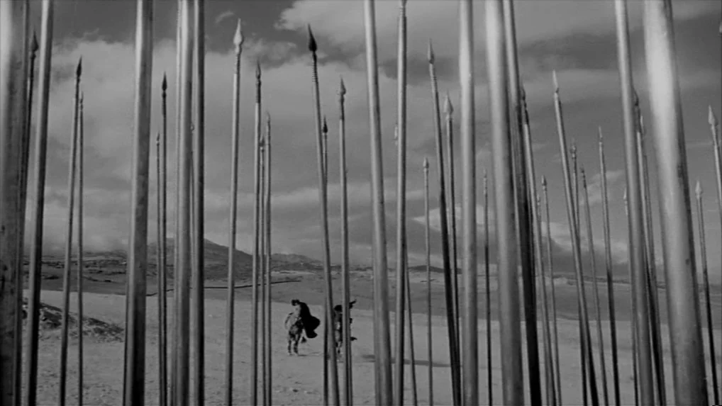 Falstaff (Chimes at Midnight) (1965) movie still: wide — A desolate, sun-bleached desert landscape is viewed through a dense foreground of tall…