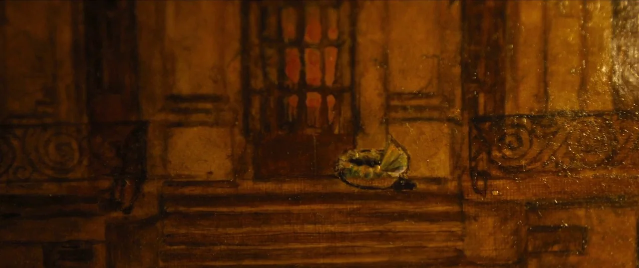 Earwig (2022) movie still: establishing — A dark, textured oil painting depicts a balcony with an ornate iron railing. A small cradle sits empty on…