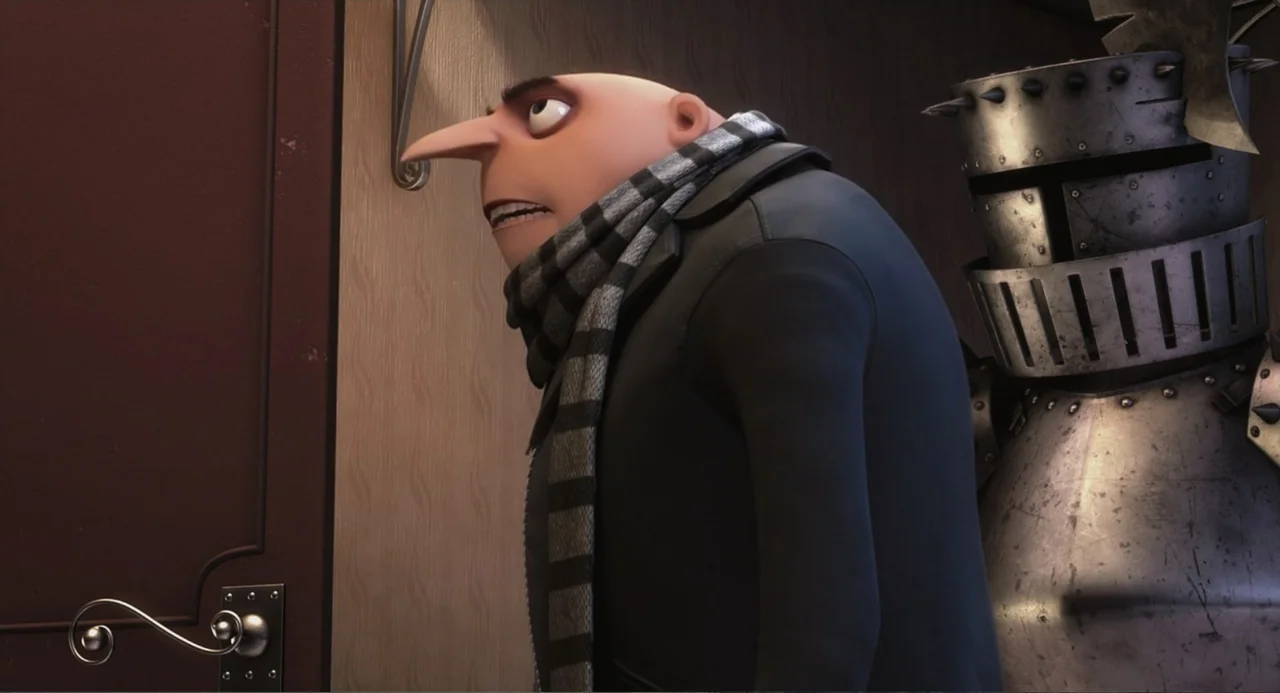 Despicable Me (2010) movie still: medium — A character stands in a hallway beside an ornate metal suit of armor. The subject wears a dark coat and…