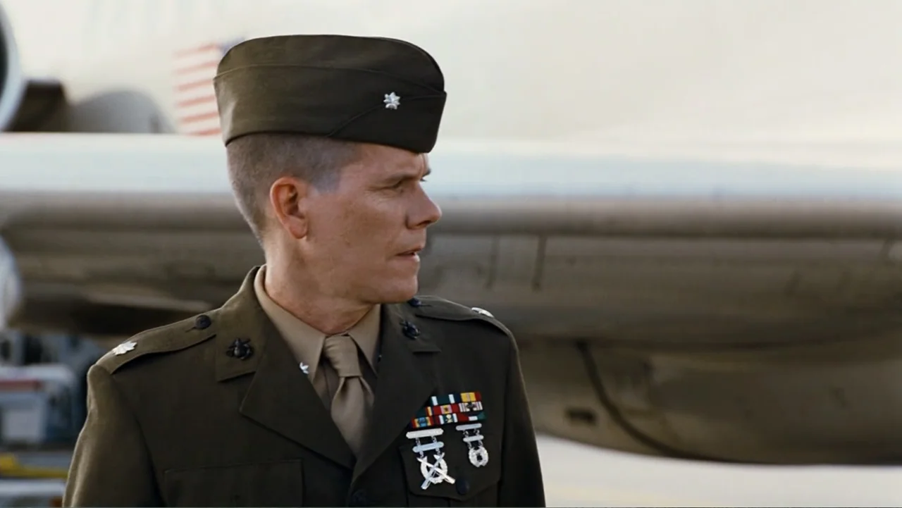 Taking Chances (2011) movie still: medium — An outdoor airfield shows a military officer standing in front of a white aircraft. The man in uniform…