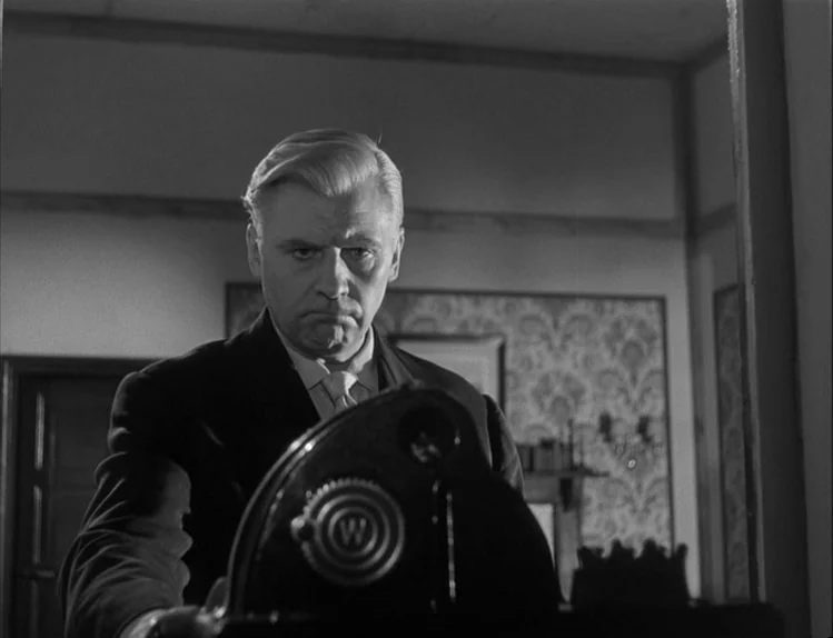 Bob le Flambeur (1956) movie still: medium — An interior space features patterned wallpaper in the background and a dark wooden object. A…